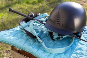 Ausrüstung zum Reiten im Freien: Zaumzeug, Peitsche, Helm, Bandagen